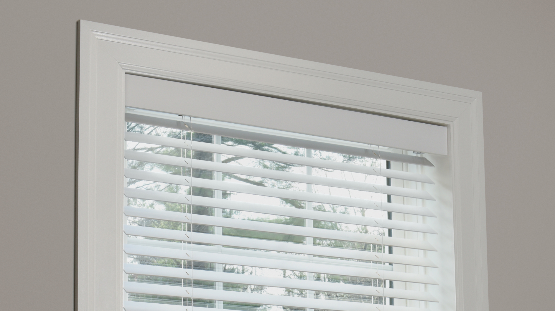 Caséta wood blinds installed in a window, showing horizontal slats filtering sunlight