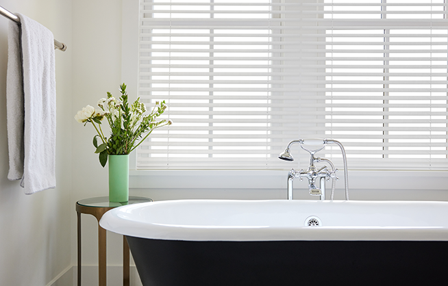 Caséta wood blinds installed in a window, showing horizontal slats filtering sunlight