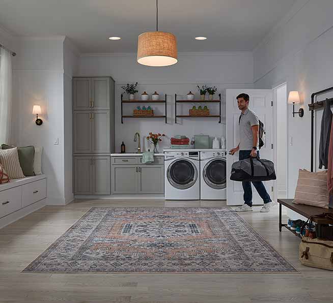 Man walking into a well lit laundry holding a bag