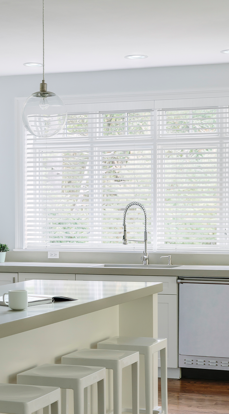 Kitchen dining nook with Caséta wood blinds filtering natural light throughout the day