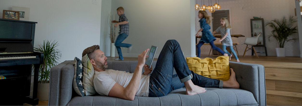 Man lounging and kids playing in home